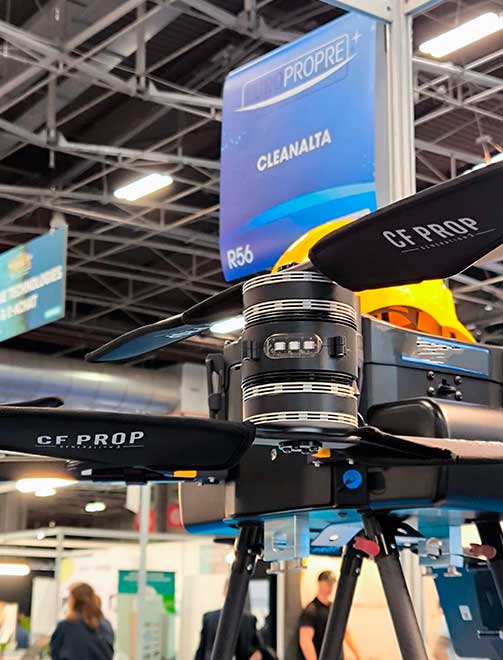 Drone CleanAlta en opération de nettoyage d'une façade industrielle, sans nacelle